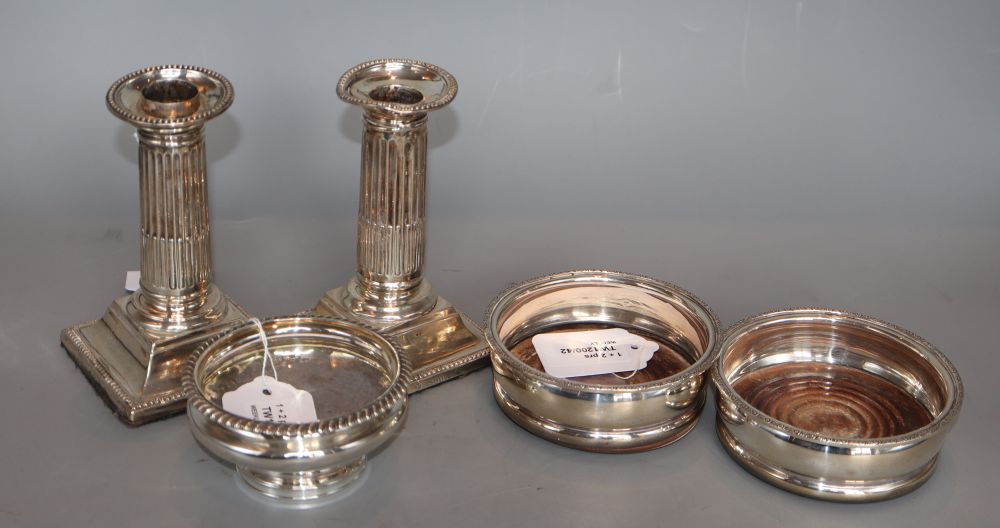 A pair of modern silver wine coasters, a pair of Victorian Doric column dwarf candlesticks (a.f.) and a George IV silver salt